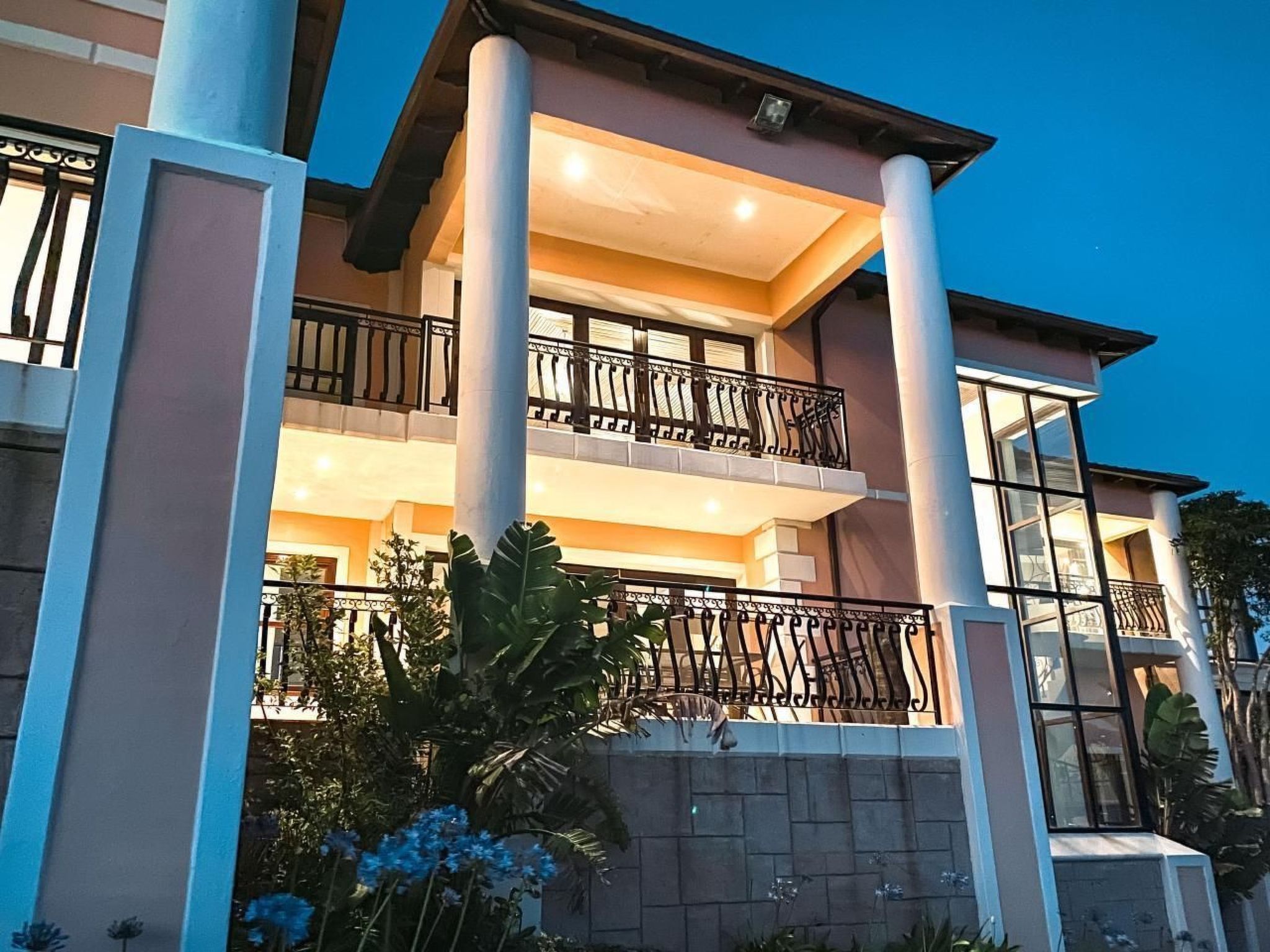 A multi-story building with a balcony, columns, and a stone facade.