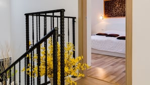 A staircase with a black railing, a wooden door leading to a bedroom with a bed and pillows, and a wall-mounted light fixture. - "Villa Agneza" by Interhome (Pula/Rakalj)