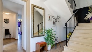 A staircase with a black railing, a wooden bench, a large mirror, and a potted plant. - "Villa Agneza" by Interhome (Pula/Rakalj)