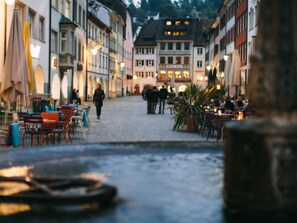 A cobblestone street lined with traditional European buildings, some with outdoor seating areas. - Apartement Feldkirch by Interhome (Feldkirch)