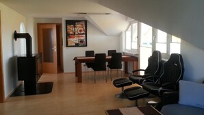 A modern living room with a dining area, a fireplace, and large windows. - Apartement Feldkirch by Interhome (Feldkirch)