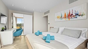 A modern hotel room with a bed, a desk, a chair, and a balcony view. - Villa Palma - Luxusvilla am Meer für 6 Personen by Interhome (Pula)