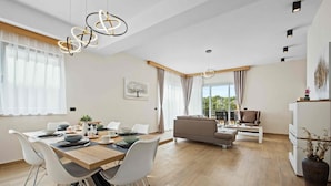 A modern living room with a dining area, a sofa, and a coffee table. - Villa Palma - Luxusvilla am Meer für 6 Personen by Interhome (Pula)