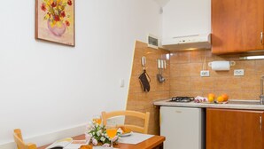 Cocina compacta con una mesa lista para el desayuno, un refrigerador pequeño y un horno empotrado.