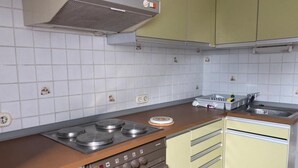 Eine Küche mit Gasherd, Backofen, Spüle und einer Arbeitsplatte mit Geschirrständer.