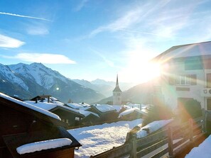 A snow-covered village with traditional buildings and a church, surrounded by mountains. - Aspa EG by Interhome (Bellwald)