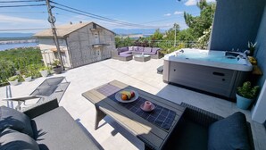 A rooftop patio with a hot tub, outdoor seating, and a scenic view. - mit privatem Pool und Sauna by Interhome (Crikvenica/Jadranovo)