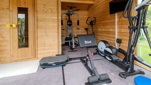 Une salle de sport équipée de divers appareils d’exercice, notamment un tapis de course, un vélo d’appartement et des appareils de musculation.