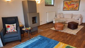 Una sala de estar moderna con chimenea, un sofá, una mesa de centro y una alfombra azul.