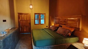 A room with a bed, a wooden headboard, a window, and a small table with a lamp. - Yaalu Yaala Safari Camp (Palatupana)