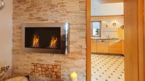 Ein modernes Wohnzimmer mit Steinwand, Kamin und integriertem Fernseher.