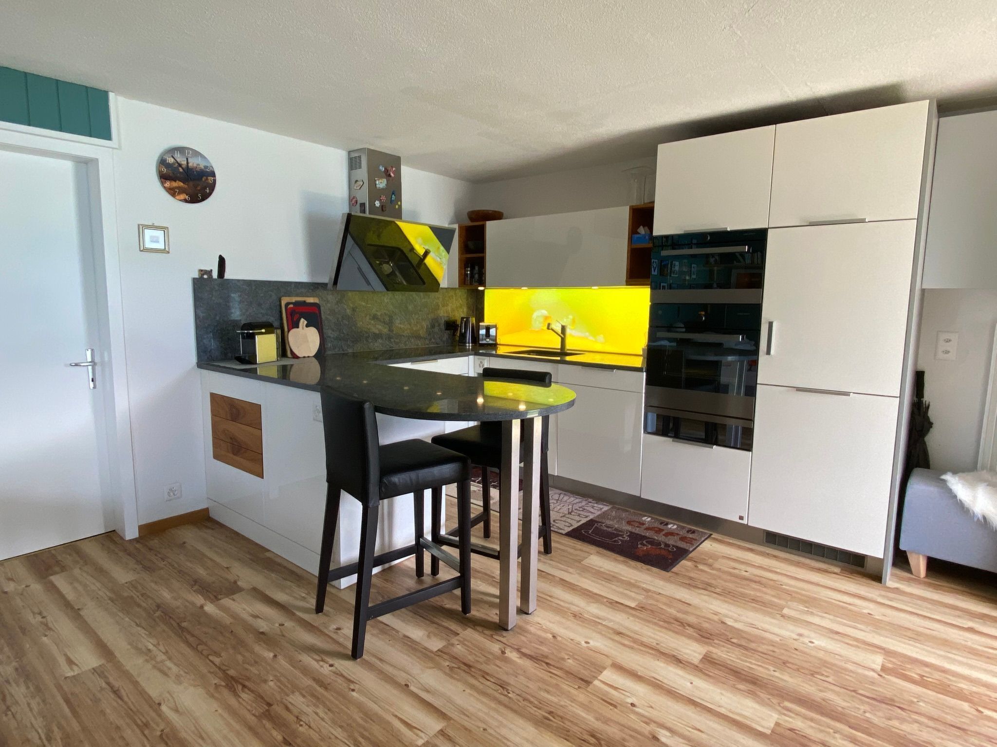 Une cuisine de taille réduite avec un îlot central, un réfrigérateur et un four à micro-ondes.