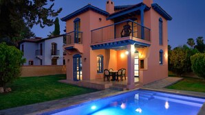 Una casa de dos pisos con piscina delantera.