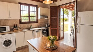 Una cocina con encimera de madera, lavadora, microondas y refrigerador.