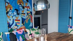 A dining area with a wooden table, colorful cushions, and a vibrant mural on the wall. - Vila Koko by Interhome (Opatija/Rukavac)