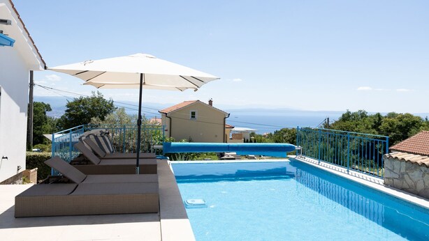 A swimming pool with a view of the sea, a lounge area with a pergola, and a building in the background. - Vila Koko by Interhome (Opatija/Rukavac)