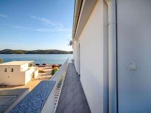 Un balcón con vistas a un lago y colinas lejanas.