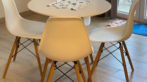 A dining area with a round table and four chairs, a television on a cabinet, and a view of the outdoors through a glass door. - BellaCasa SrimaSmart by Interhome (Vodice)