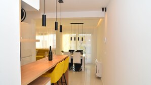 A modern kitchen with a wooden countertop, yellow bar stools, and pendant lighting. - Wohnung Bruno - Luxuriöses Penthouse by Interhome (Zadar)