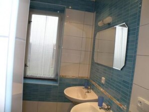 A bathroom with two sinks, a window, and blue-tiled walls. - Villa "Na Hora" mit Garten, Grill und Terrasse by Interhome (Malé Svatonovice)