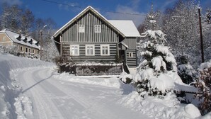 A wooden house with a snow-covered roof and a wooden fence in front. - Charmantes, traditionelles Holzhaus by Interhome (Jilemnice)