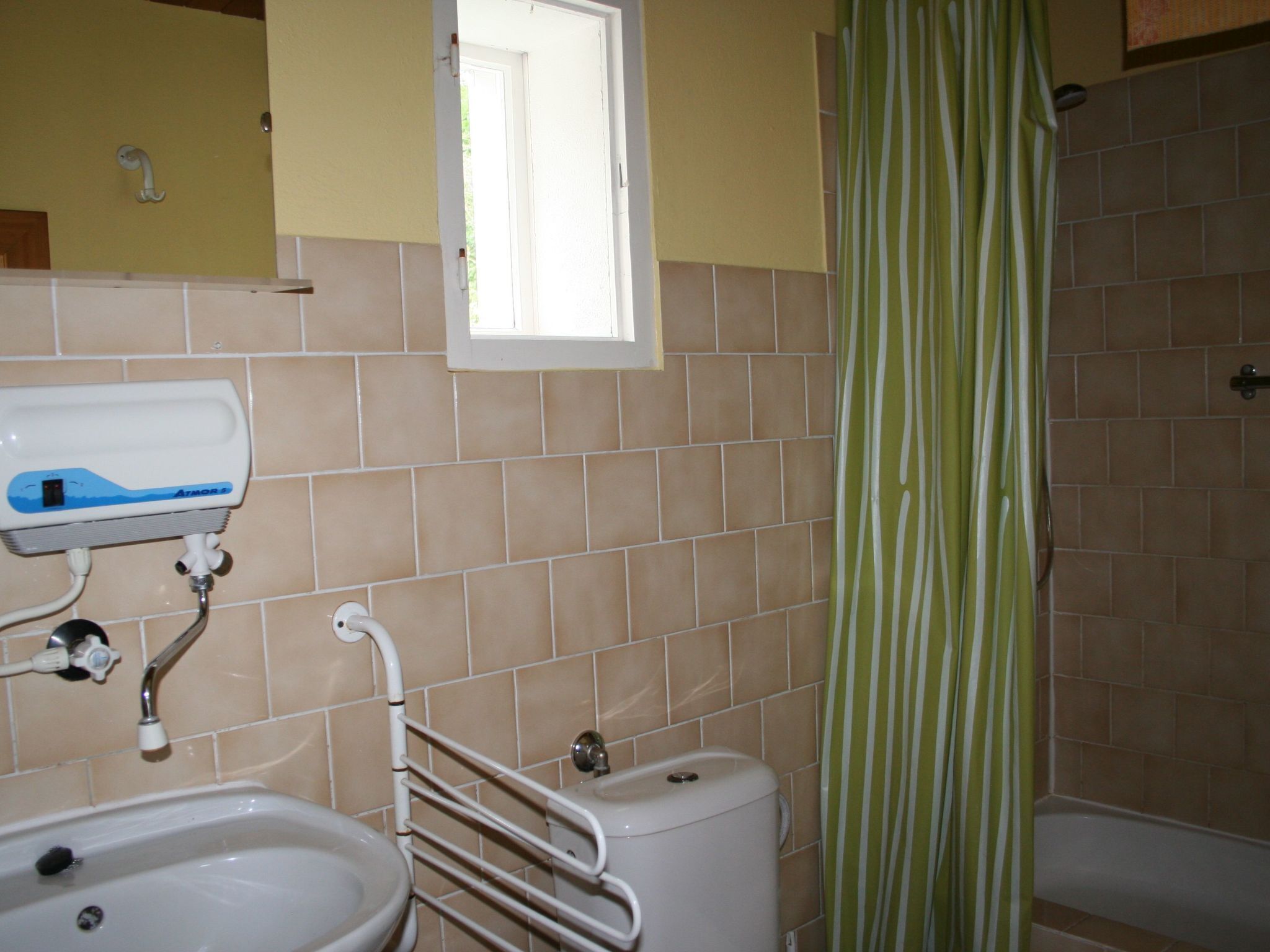 A bathroom with a sink, toilet, and shower.