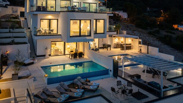A modern two-story house with a swimming pool, outdoor seating, and a view of the surrounding landscape. - in Dvornica mit Privatem Pool by Interhome (Podorljak)