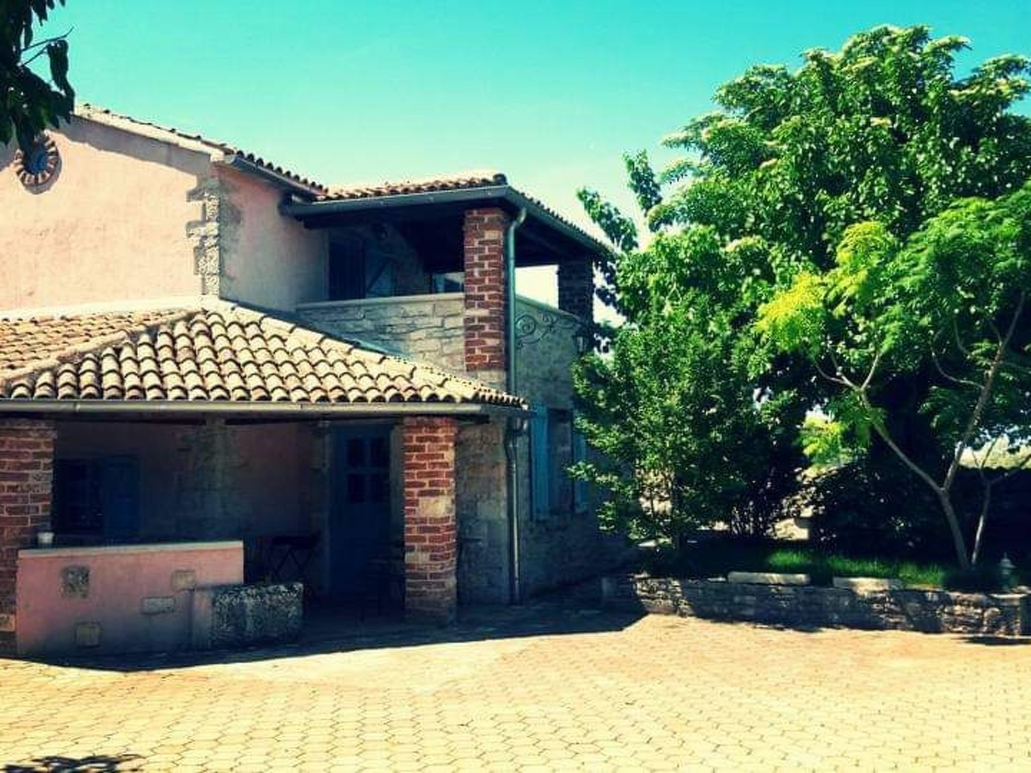 A building with a tiled roof, brick walls, and a paved courtyard.