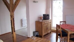 A cozy room with a wooden table, chairs, a radiator, and a window. - Zu den drei Schönen by Interhome (Boitzenburger Land)