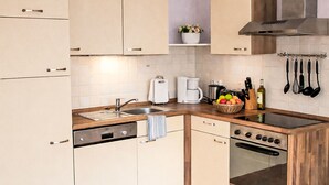 Een moderne keuken met een vaatwasser, oven en koffiezetapparaat.