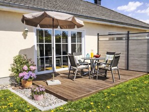 A patio with a table and chairs, a potted plant, and a sliding glass door. - in Pruchten mit Sauna und Kamin by Interhome (Bodstedt)