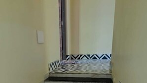 Un escalier étroit avec des marches alternant entre le noir et le blanc, menant à une porte située en haut.