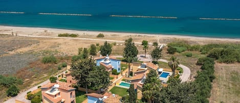 A coastal resort with villas, a swimming pool, and a beach view.