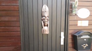 A black door with a vertical panel design and a decorative wooden carving. - in Kuhklingen mit Großer Terrasse by Interhome (Wald-Michelbach)