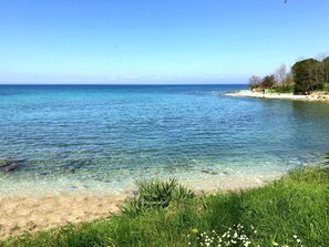 A beach with clear water, a sandy shore, and green vegetation. - Silva B4+1 by Interhome (Umag/Savudrija)