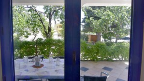An outdoor patio with a table set for dining, surrounded by greenery and a view of the neighborhood. - Gilda Punta B4 by Interhome (Umag)