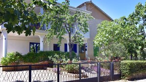 A two-story building with a white facade, blue shutters, and a gated entrance. - Gilda Punta B4 by Interhome (Umag)