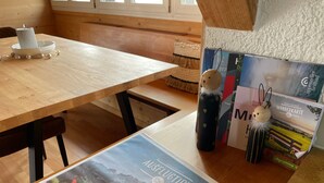 Een houten tafel met een kaars, een reisgids en een decoratief object.