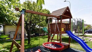 Un espai de jocs amb balancà, tobogan i estructura per escalar.