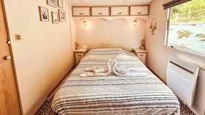 Ein Schlafzimmer mit Bett, Nachttischen, einem Fenster mit Ausblick und Wandregalen.