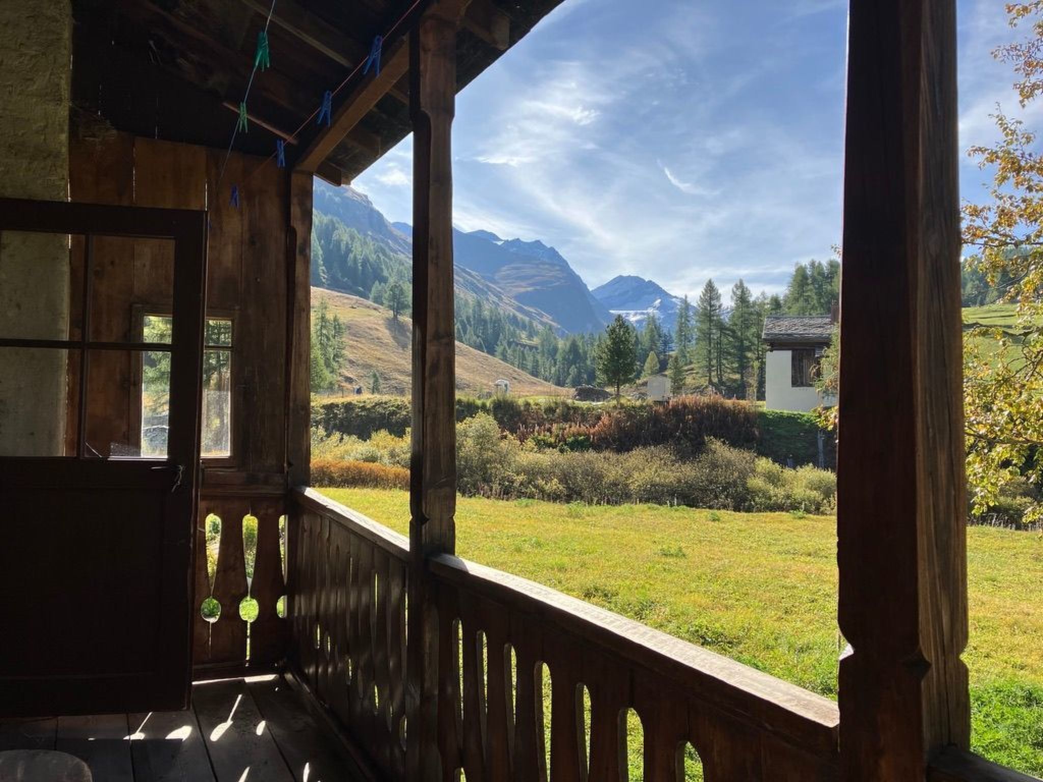 Ein hölzerner Balkon mit Blick auf eine gebirgige Landschaft.