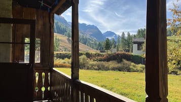 Ein hölzerner Balkon mit Blick auf eine gebirgige Landschaft.
