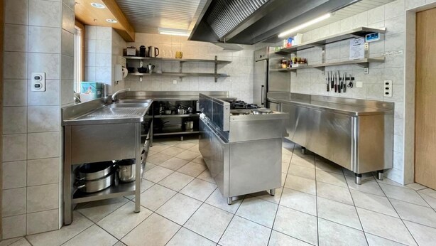 Een moderne keuken met roestvrijstalen apparatuur, een centraal eiland en een afzuigkap.