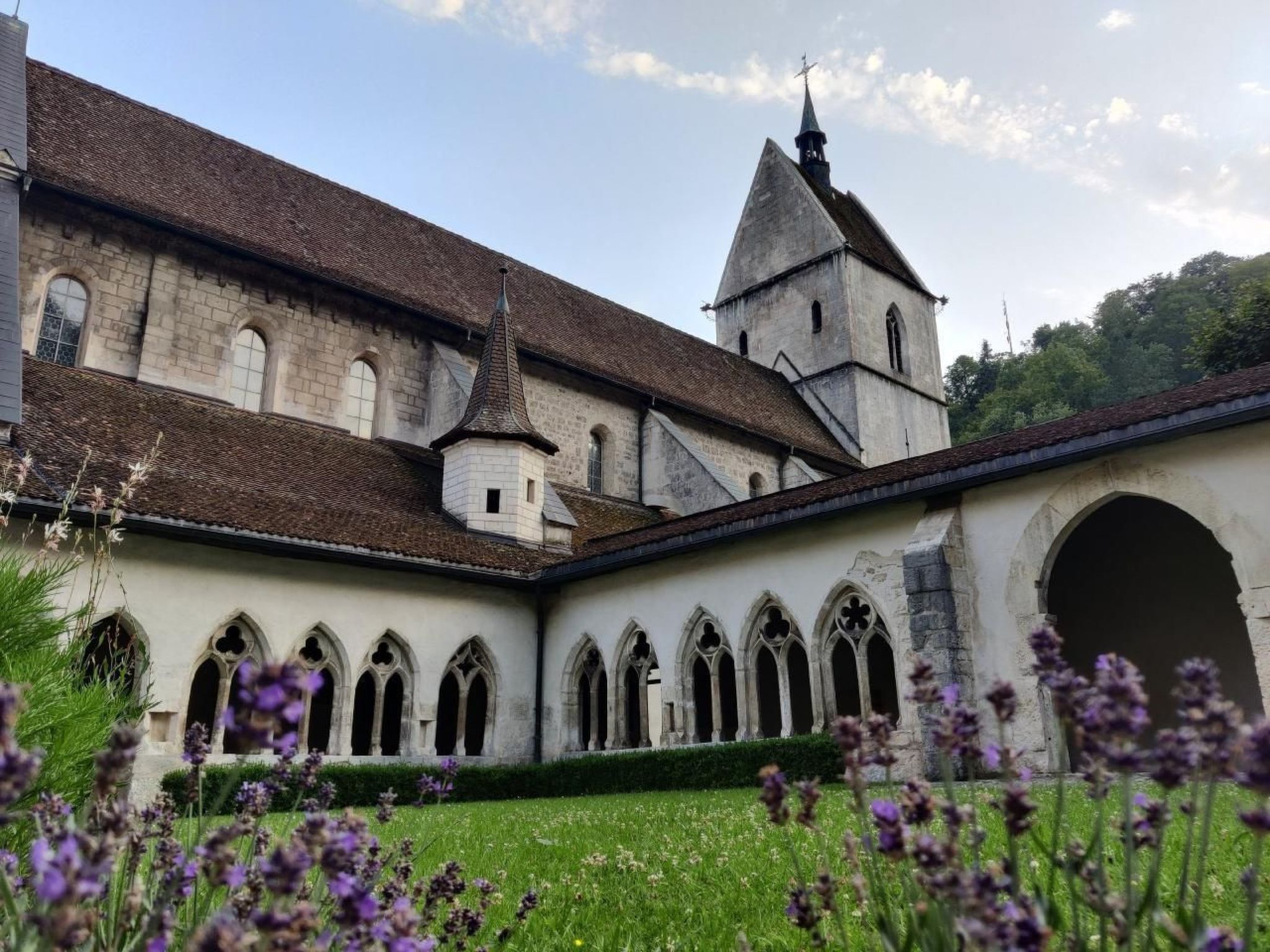 Ein historisches Gebäude mit Innenhof, Bogenfenstern und einem Turm.