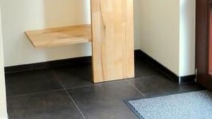 A room with a wooden wardrobe, a hanging shelf, and a tiled floor. - Fewo Ginkgo II by Interhome (Dresden)