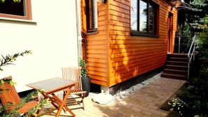 A wooden cabin with a patio area, a table, and chairs. - Fewo Ginkgo II by Interhome (Dresden)