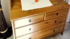 Eine hölzerne Kommode mit Schubladen und einem Spiegel darüber.