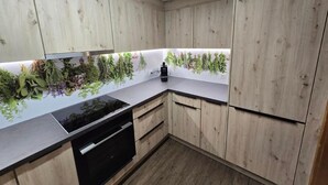 Una cocina con armarios de madera, un lavavajillas negro y una encimera con un jardín de hierbas.
