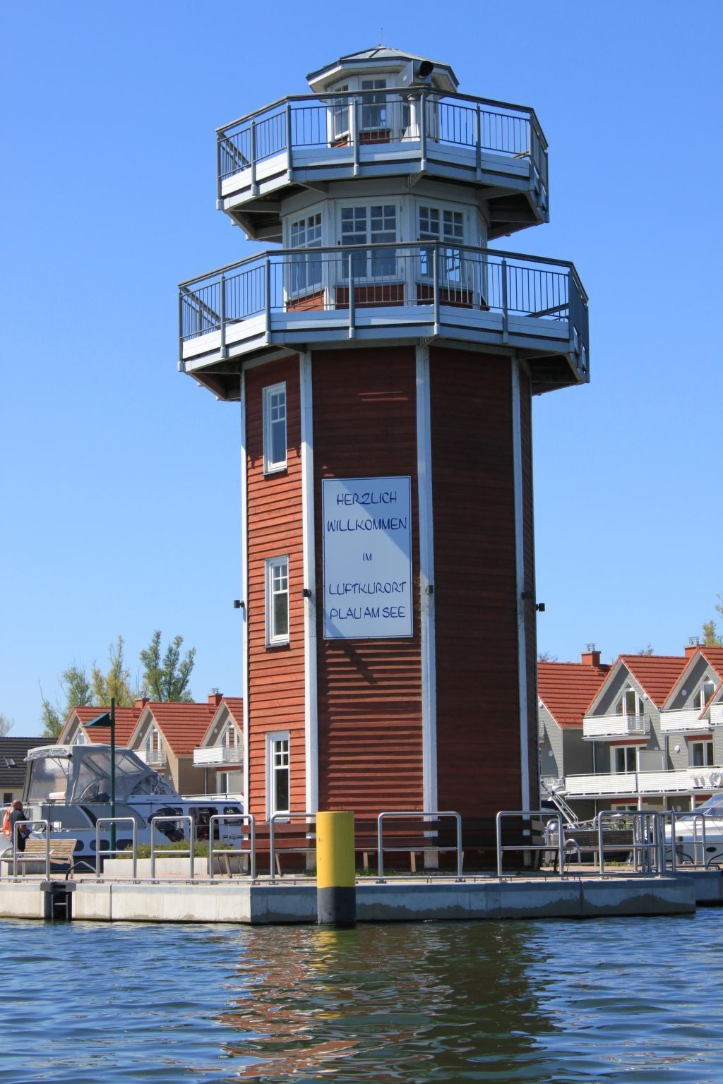 Um farol com uma placa que diz "Herzlich Willkommen im Luftkurort Plau am See".