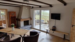 Un salon moderne avec une cheminée, des meubles en bois et un téléviseur.